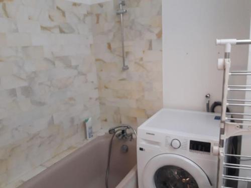 La salle de bains est pourvue d'un lave-linge et d'une baignoire. dans l'établissement Appartement avec terrasse - Calme et soleil - Proche de la plage, à Marseille