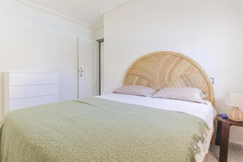 a bedroom with a large bed with a green blanket at Casa El Sole in Mazarrón