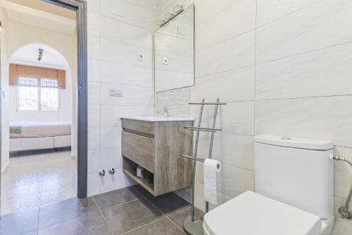 a white bathroom with a toilet and a sink at Casa El Sole in Mazarrón
