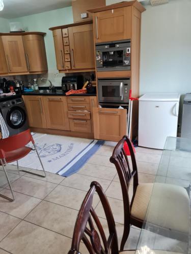 a kitchen with wooden cabinets and a table and chairs at 75 Park Prewett Room with Juliet balcony in Basingstoke