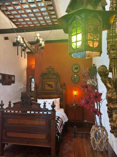 a bedroom with a bed and a chandelier at Hotel Boutique Casa de Hacienda Su Merced in Puembo