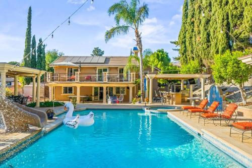 a house with a swimming pool with swans in it at Resort Home with Games, Slide, Oasis in Los Angeles