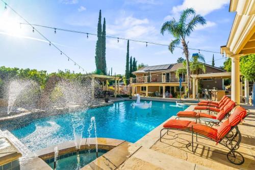a pool with chairs and a fountain at Resort Home with Games, Slide, Oasis in Los Angeles