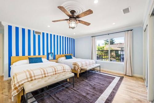 a bedroom with two beds and a ceiling fan at Resort Home with Games, Slide, Oasis in Los Angeles
