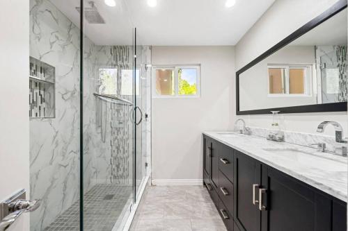 a bathroom with a glass shower and a sink at Resort Home with Games, Slide, Oasis in Los Angeles
