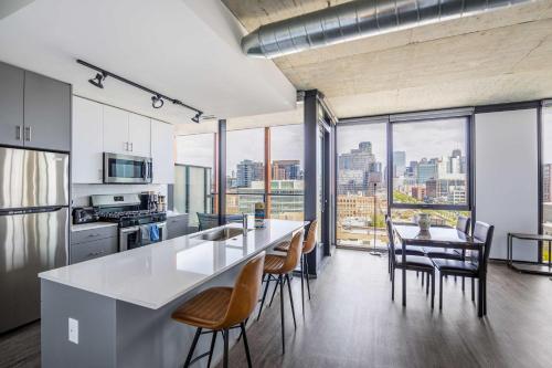 an open kitchen and dining room with a view of the city at Freshly Minted 2BR - Elegance & Comfort in Central Chicago in Chicago