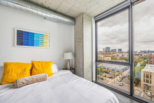 a bedroom with a bed and a large window at Freshly Minted 2BR - Elegance & Comfort in Central Chicago in Chicago