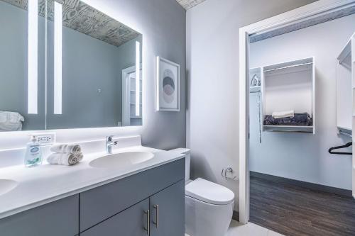 a white bathroom with a sink and a toilet at Freshly Minted 2BR - Elegance & Comfort in Central Chicago in Chicago