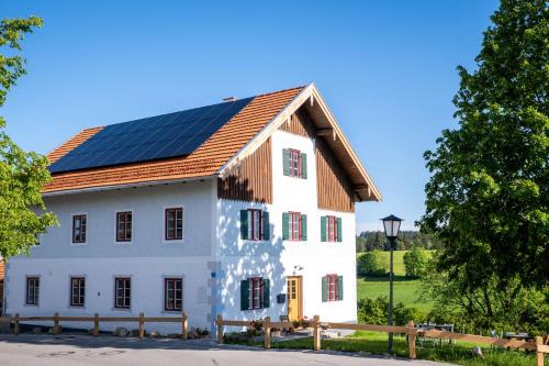 a white house with solar panels on its roof at Pilgerhaus Wildsteig in Wildsteig