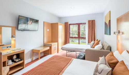 a bedroom with a bed and a living room at High Range Lodge Hotel in Aviemore