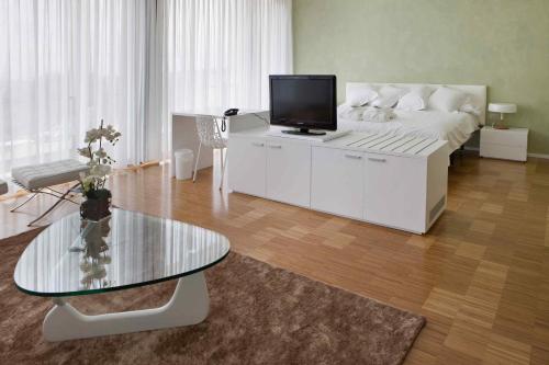 sala de estar con cama y mesa con TV en Hotel-Bodega Finca de Los Arandinos, en Entrena