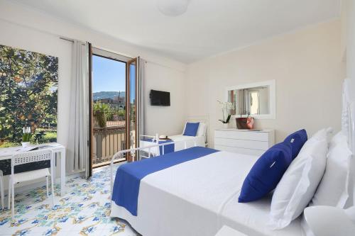 a white bedroom with a large bed and a balcony at Casa Lucy in Sorrento