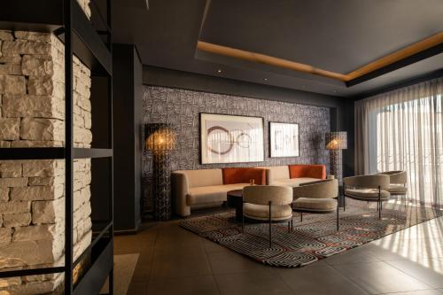 a living room with a couch and chairs at Mercure Hotel Windhoek in Windhoek