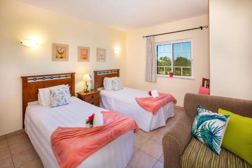 1 dormitorio con 2 camas, sofá y ventana en Apartamentos Monte dos Avós, Albufeira by AlgarveBlossom, en Albufeira