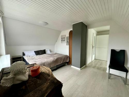 a bedroom with a bed and a table and a chair at Ferienhaus Achterhus für Familien & Homeoffice in Ratekau