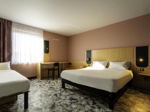 a hotel room with two beds and a desk at B&B HOTEL Maubeuge Gare in Maubeuge