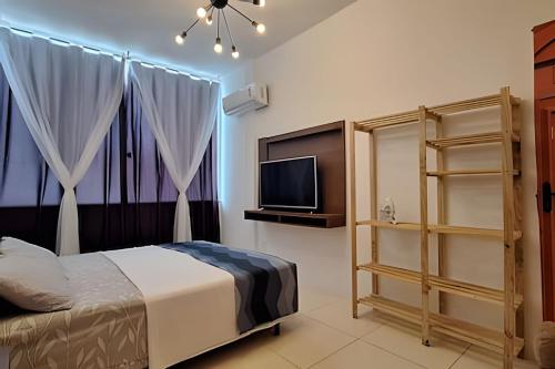 a bedroom with a bed and a flat screen tv at sétimo andar, excelente vista. in Salvador