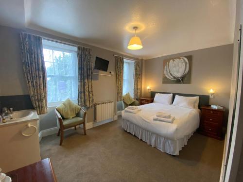 a bedroom with a bed and a sink and a tub at Le Chene Hotel in St Peter Port