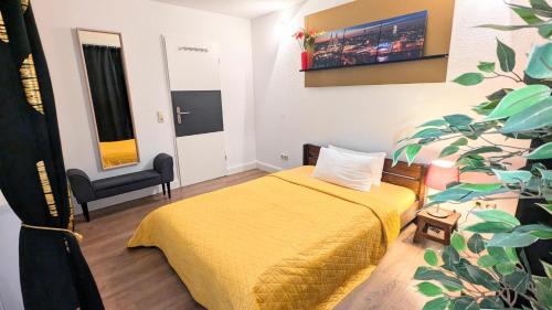 a bedroom with a yellow bed and a plant at Gästewohnung Köln-Longerich in Cologne