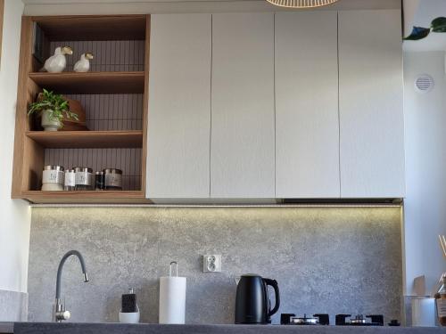 a kitchen with white cabinets and a sink at Apartament Coffee Time in Tarnów