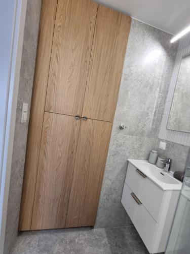 a bathroom with a large wooden cabinet next to a sink at Apartament Coffee Time in Tarnów