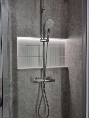 a shower with a shower head in a bathroom at Apartament Coffee Time in Tarnów
