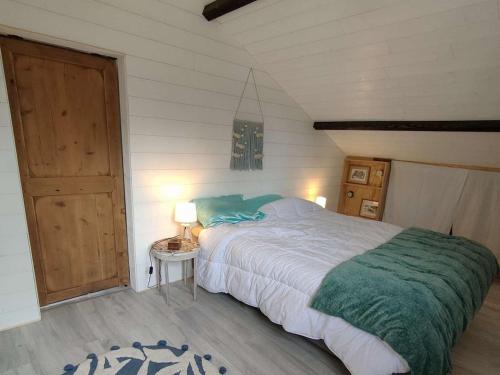 une chambre avec un grand lit avec une couverture verte dans l'établissement Villa landaise avec studio indépendant, proche bassin, commerces et plages - 8 pers., jardin, WiFi - FR-1-736-29, à Lège-Cap-Ferret