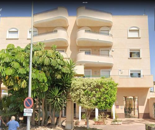 a tall building with trees in front of it at Lemon Apartment - Aquamarina Cabo Roig in Playas de Orihuela