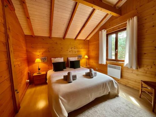 sypialnia z łóżkiem w drewnianym pokoju w obiekcie La Charmelle - Belle maison avec jardin & terrasse w mieście Corcieux