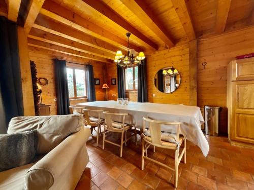 une salle à manger avec une table et des chaises blanches dans l'établissement La Charmelle - Belle maison avec jardin & terrasse, à Corcieux