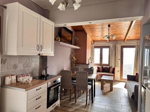 a kitchen with white cabinets and a table with chairs at Lydias House in Arachova