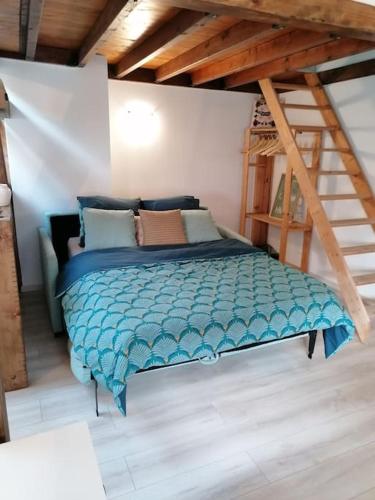 une chambre avec un lit avec une couette bleue dans l'établissement L'Essentiel-Appartement neuf et cosy avec piscine, à Pfastatt