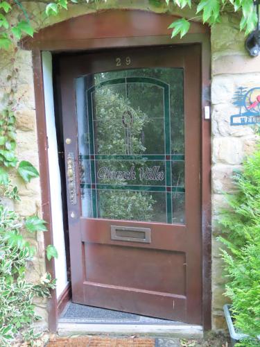 a brown door with a sign that reads christmas village at Church Villa B&B in Chesterfield