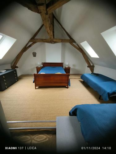 une chambre avec deux lits dans un grenier dans l'établissement Gîte de la vallée à Courdemanche Sarthe, à Courdemanche