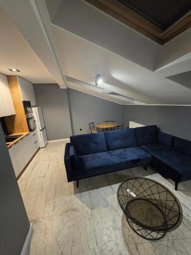 a living room with a blue couch and a table at Apartament w Centrum z Jacuzzi, prywatny parking, klimatyzacja 4 in Radom