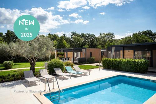 a villa with a swimming pool and a house at Camping Park Umag Mobile Homes in Umag