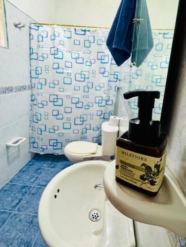 a bathroom with a bottle of moisturizers on a sink at Cabaña flores en la colina in Barbosa