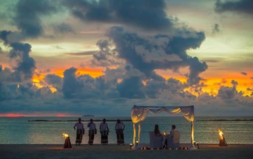 a wedding ceremony on the beach at sunset at Sun Siyam Iru Fushi with Free Transfer in Manadhoo