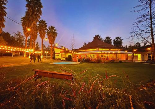 a building with lights in a park at night at Hostería Valle Verde in Villa Alemana