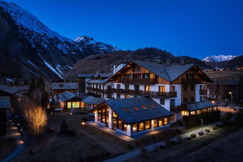 an aerial view of a hotel at night with mountains at Montana Lodge & Spa, by R Collection Hotels in La Thuile