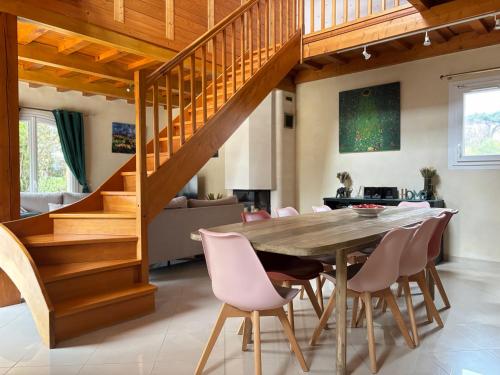 a dining room with a wooden table and chairs at Le So Art, grande maison 4 chambres, terrain de pétanque, grand jardin clos, flipper, babyfoot, jeux Arcade, ping pong,1 km mer, proche golf, Port en Bessin, Bayeux et plages du débarquement, adaptée enfants in Commes
