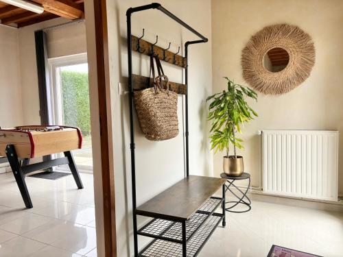a room with a bench and a plant in it at Le So Art, grande maison 4 chambres, terrain de pétanque, grand jardin clos, flipper, babyfoot, jeux Arcade, ping pong,1 km mer, proche golf, Port en Bessin, Bayeux et plages du débarquement, adaptée enfants in Commes