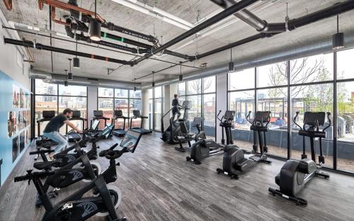 a gym with several people exercising on tread machines at Sophisticated 3BR Suite - New Modern and Luxurious in Chicago