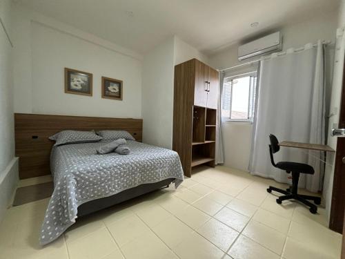 a bedroom with a bed and a desk and a chair at Cantinho do Mané in Florianópolis