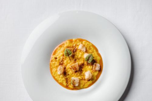 a bowl of food on a white plate at Montana Lodge & Spa, by R Collection Hotels in La Thuile