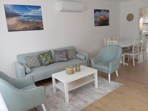 a living room with a couch and chairs and a table at Casa Amarela in Bolembre de Baixo