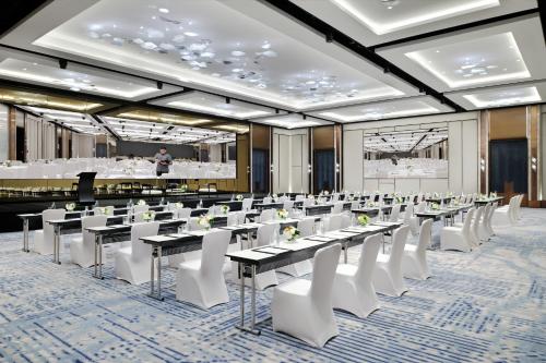 a conference room with tables and white chairs at Crowne Plaza Dubai Festival City in Dubai