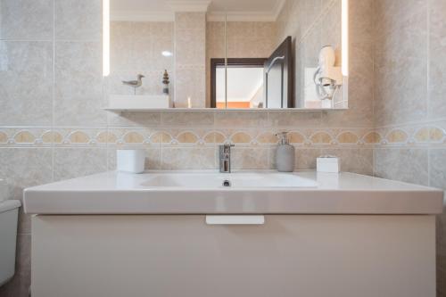 a bathroom with a white sink and a mirror at Villa Montaña Negra III in San Bartolomé de Tirajana