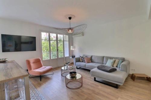 un salon avec un canapé et une chaise dans l'établissement Charmant T2 avec balcon - Parking, AC, Wifi, à Ajaccio