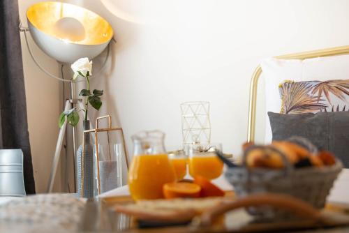 - une table avec des verres de jus d'orange et un panier de pain dans l'établissement The Charming Rue Cler, à Paris